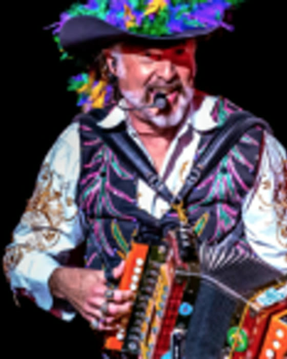 Mister Mojo playing accordion in a Mardi Gras hat.